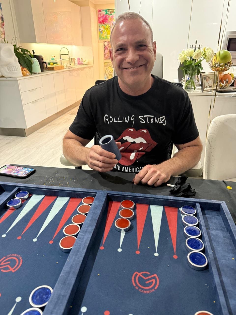 Ryan Eber shaking a dice cup at a backgammon board